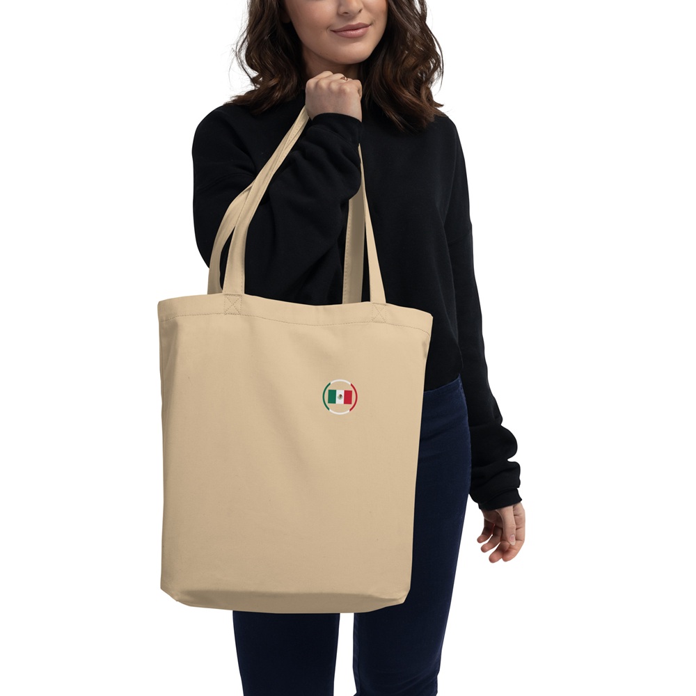 Tote bag beige avec motif circulaire inspiré du drapeau mexicain Tote bag beige porté à la main avec petit motif circulaire aux couleurs du Mexique