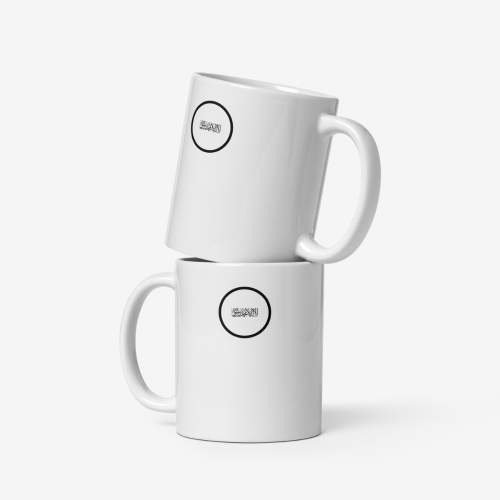 Deux mugs en céramique blanche empilés, avec le mug supérieur incliné vers la droite, chacun portant un logo circulaire noir affichant l’écriture du drapeau de l’Afghanistan.