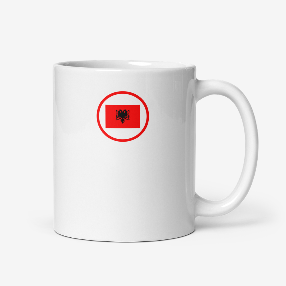 Mug blanc avec emblème albanais circulaire rouge Mug en céramique blanche vu de face, avec un logo circulaire rouge représentant l’aigle noir à deux têtes du drapeau de l’Albanie.