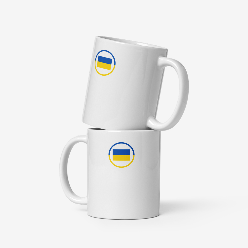 Deux mugs en céramique blancs vus de face, empilés verticalement, chacun avec un motif circulaire bleu et jaune représentant le drapeau ukrainien.